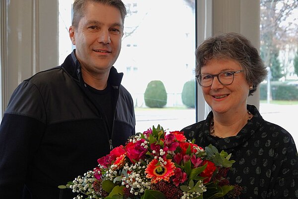 Zwei Personen mit Blumenstrauß