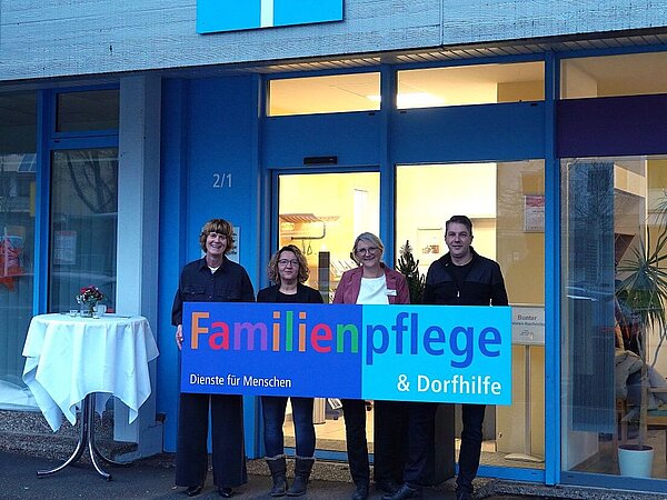 Vier Personen halten Schild "Familienpflege und Dorfhilfe"