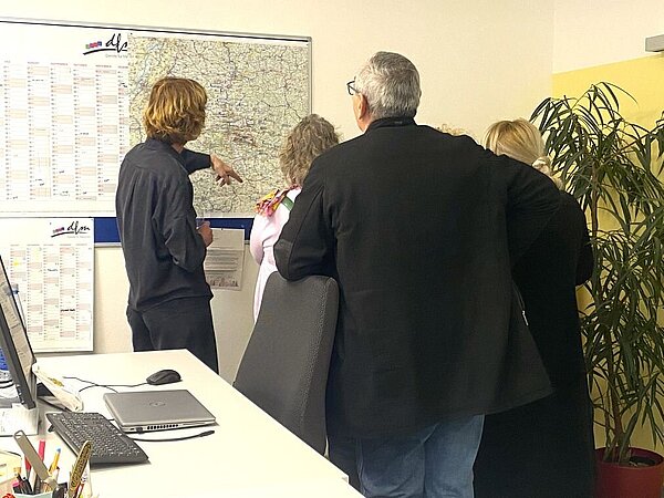 Person zeigt anderen Personen neue Büros